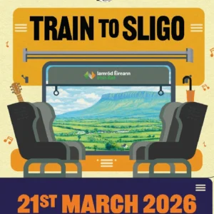 An illustrated event poster for 'Train to Sligo,' part of the Five Lamps Arts Festival 2026. The graphic shows a stylized train interior with two seats facing a window that looks out onto a green landscape and Benbulbin mountain. The Iarnród Éireann Irish Rail logo is visible on the glass, and musical notes float around a guitar and an umbrella. The bottom text reads: 21st March 2026, 9am, Connolly Station