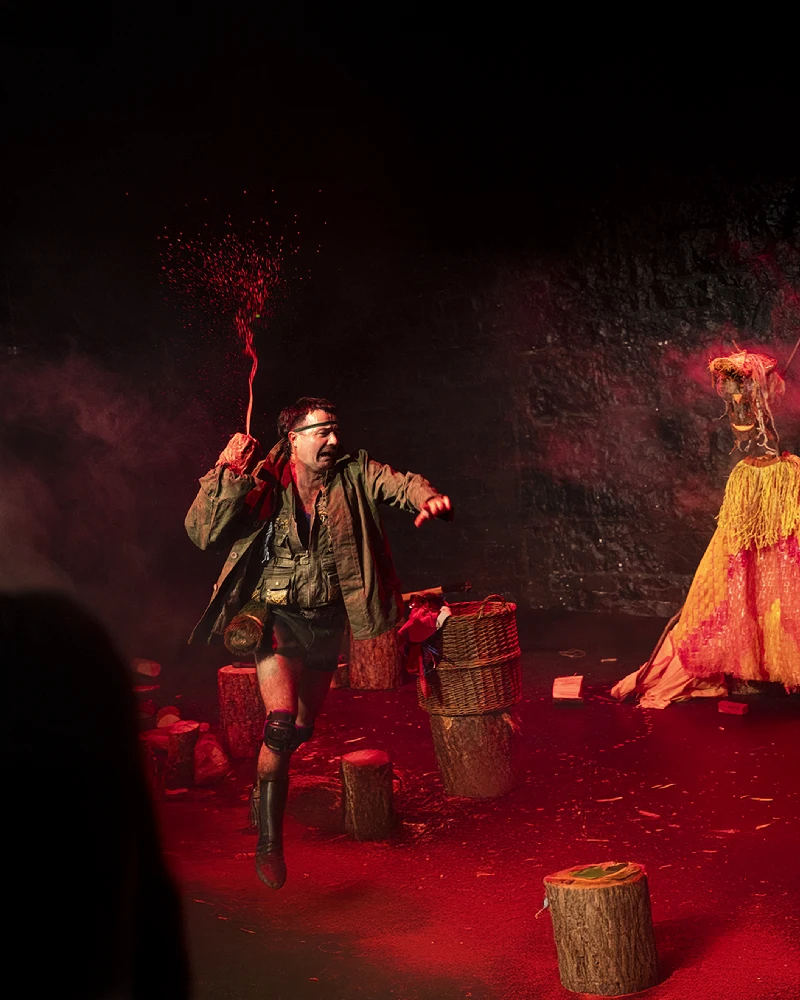 A lone wood-chopper performing a physical comedy and clowning act with real axes and wood as part of the CHOP theatre show for The Five Lamps Arts Festival 2026.